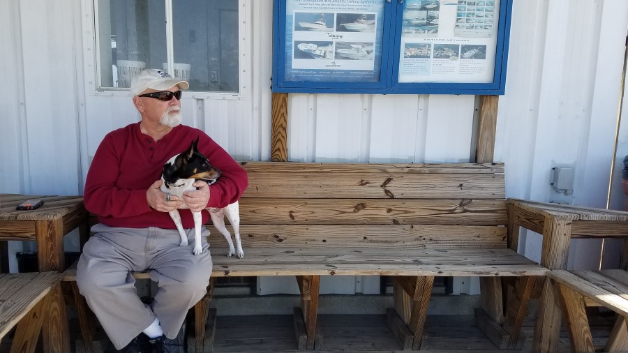 Fish Cleaner Bucky Mann sits with his dog Maggie