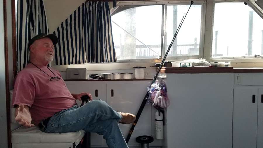 Captain Frank Smith sitting and talking aboard his boat