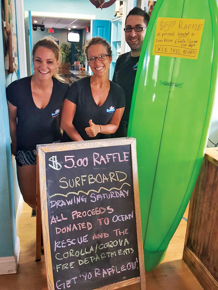 Uncle Ike's employees with surfboard up for raffle