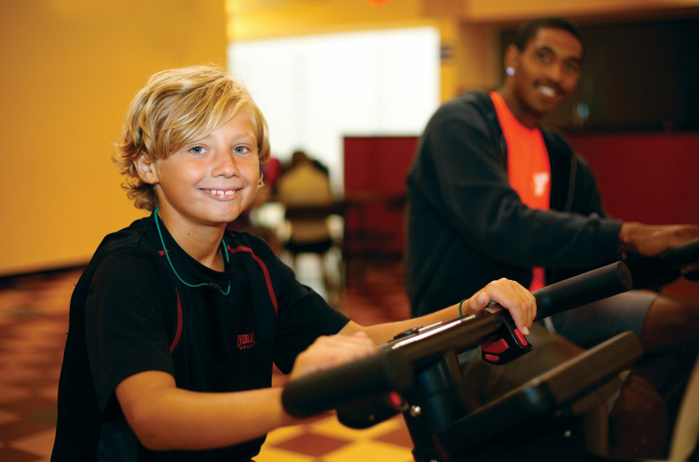 Child and young adult on workout equipment at the Outer Banks Family YMCA