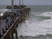 Dark skies and white-water ocean waves surround ocean fishing pier