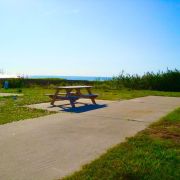 Every site features a concrete pad, grassy area, and picnic table