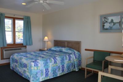 Poolside bedroom with queen bed at Pony Island Motel