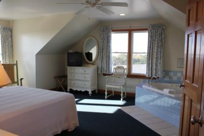 Bed and bathtub of poolside room at Pony Island Motel