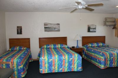Room with two double beds and a twin bed at Pony Island Motel